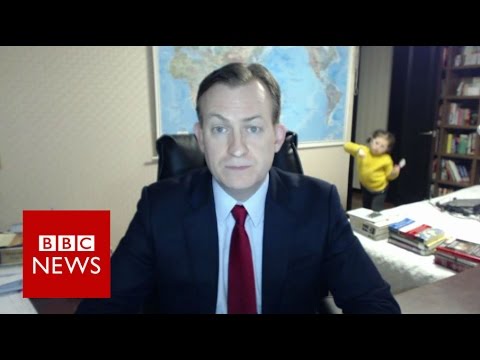 Child walks in the frame of a BBC news reporter while he is on air. 